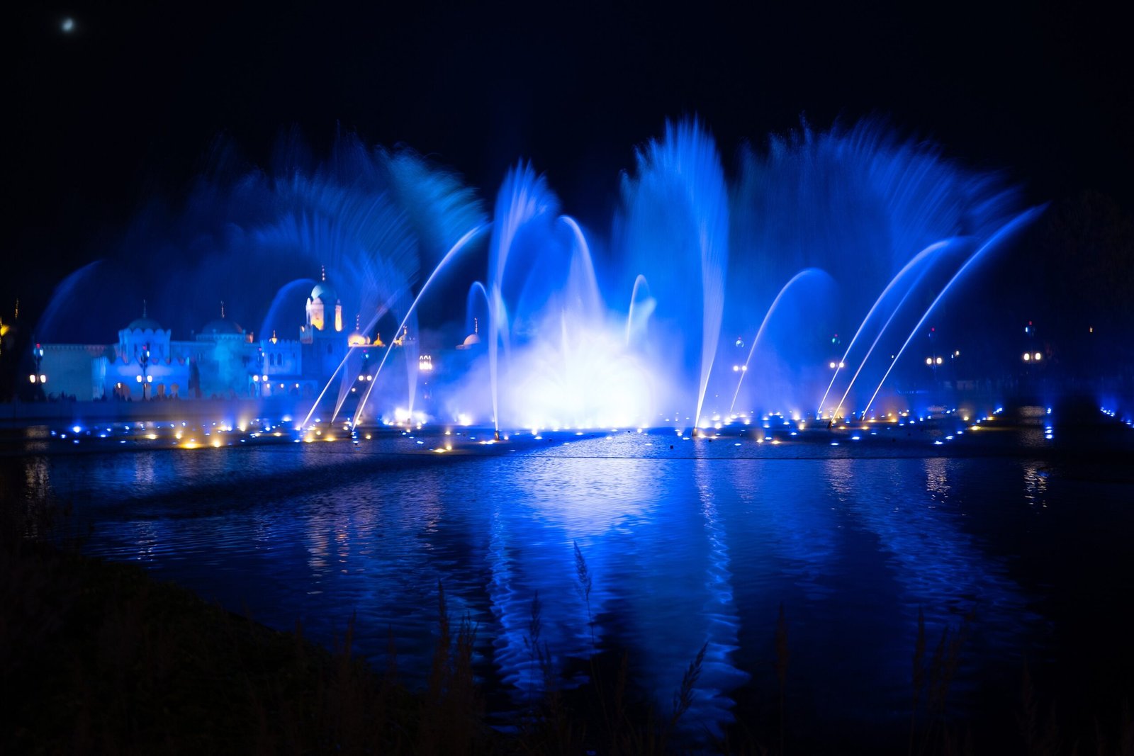 Le fontane illuminate di blu dello spettacolo Aquanura sul lago di Efteling, di sera