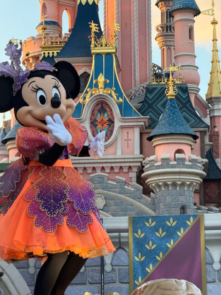 Minnie con l'abito arancione di Halloween davanti al castello della Bella Addormentata