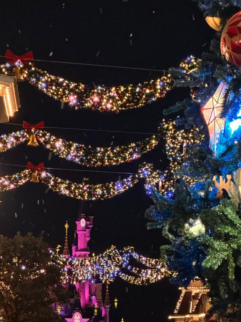 Ghirlande luminose di Natale appese su Main Street con il castello illuminato sullo sfondo