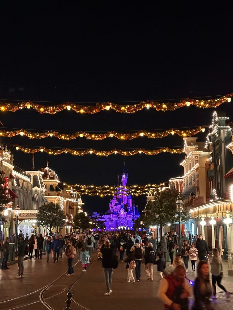 Main Street, U.S.A. di sera con le luci natalizie e il castello illuminato in fondo alla strada